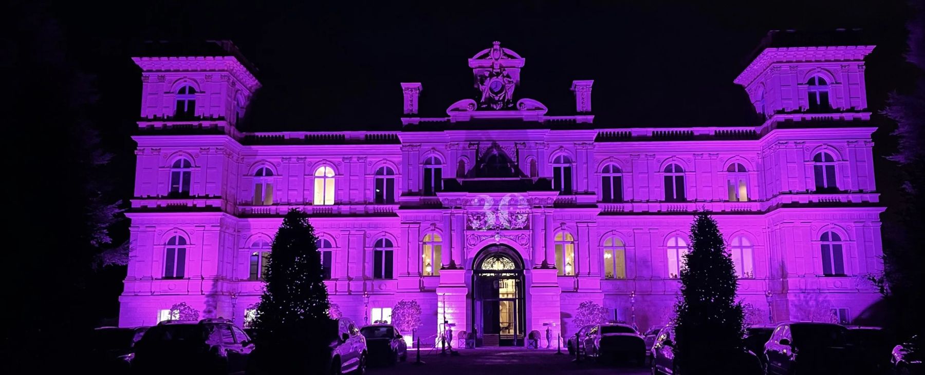 Façade de château mise en lumière violette